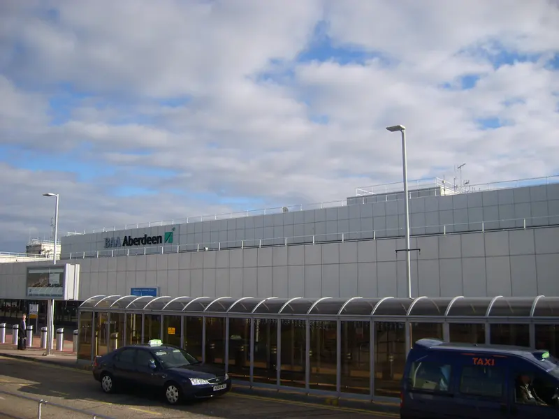 The terminal building at Aberdeen Airport with taxis waiting under the covered walkway