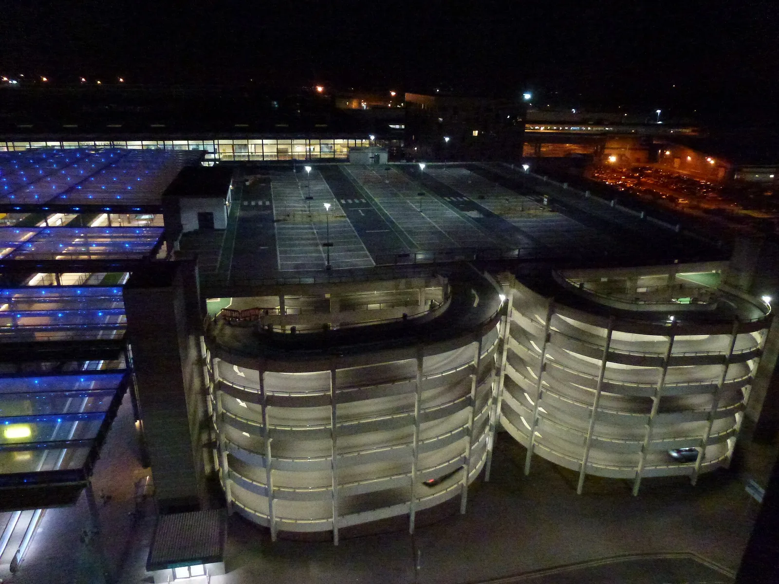 The curved multi-storey car park at Gatwick North Terminal lit up at night